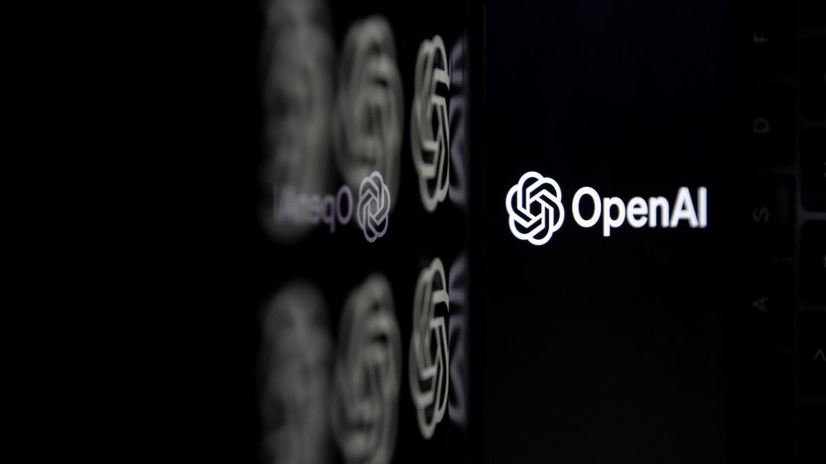 DALL-E 3 launch: The OpenAI logo in white (circles wrapping over one another next to the words &quot;OpenAI&quot;) on the right of frame against a dark background. It is being reflected against a glassy surface across the left of the frame.