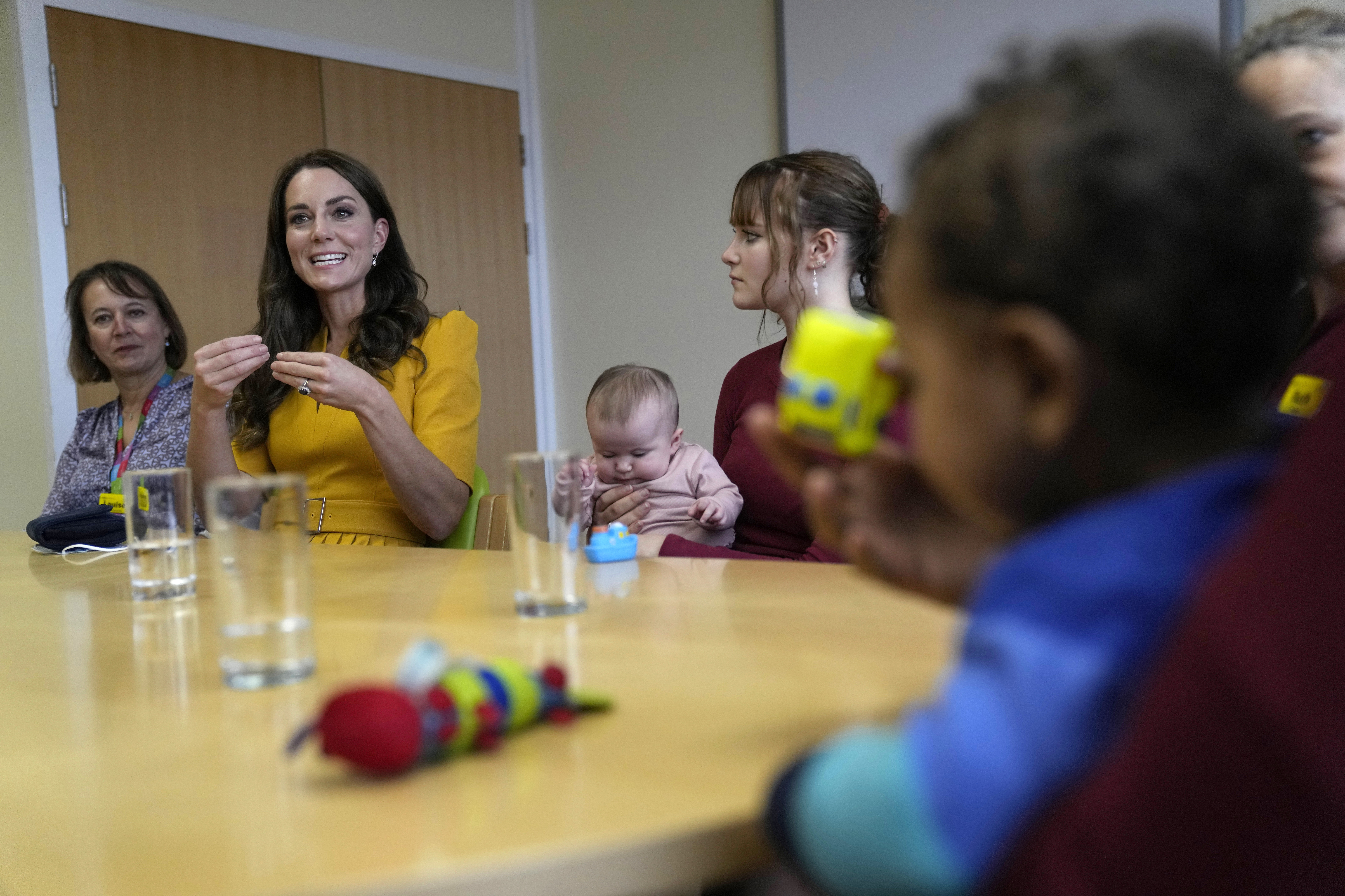 Kate Middleton wears a yellow dress to visit the Royal Surrey County Hospital's Maternity Unit on October 5, 2022