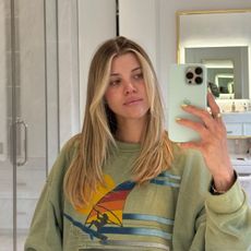 Sofia Grainge taking a selfie in a bathroom with long hair