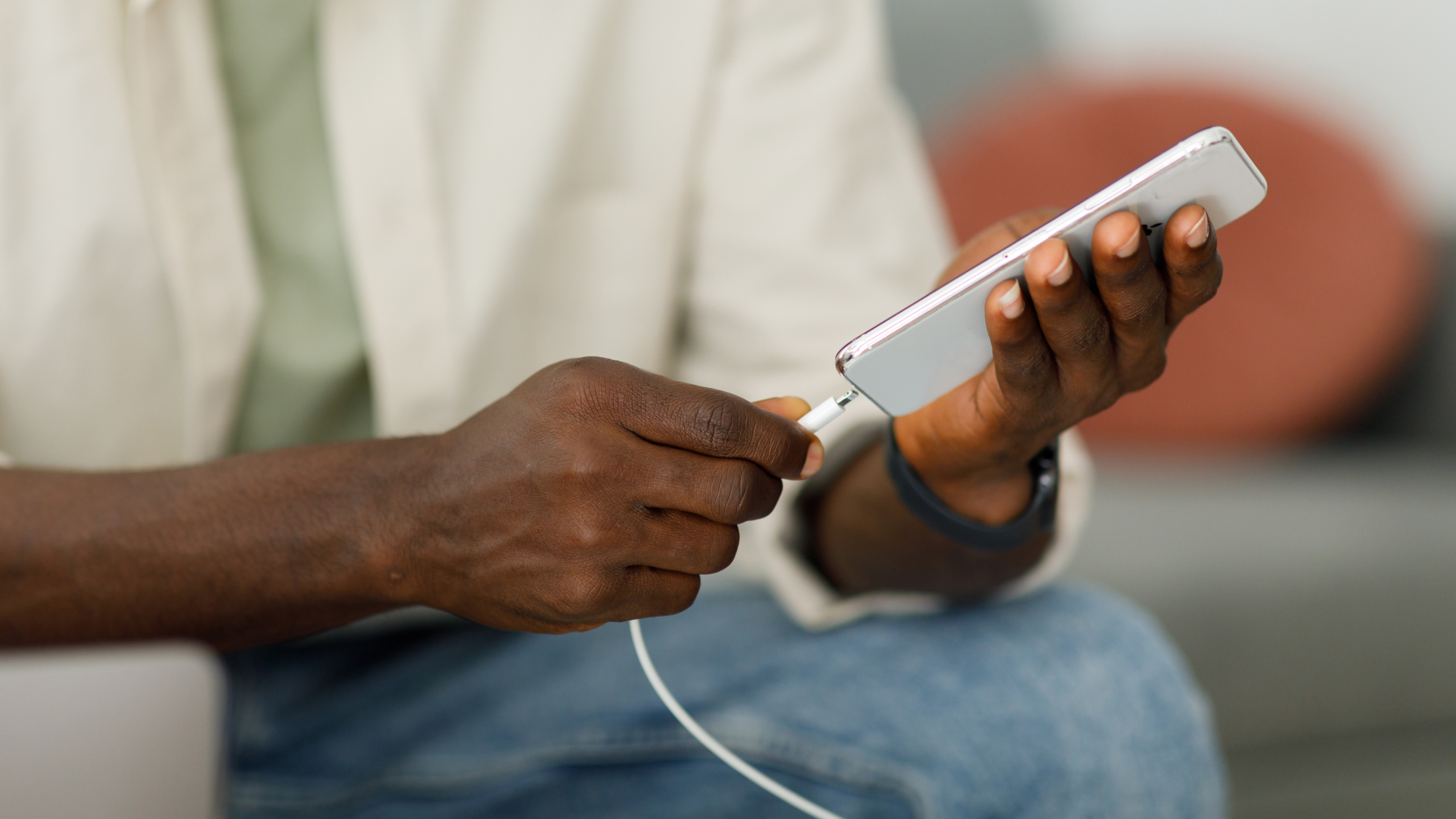 A man plugging a charging cable into his phone