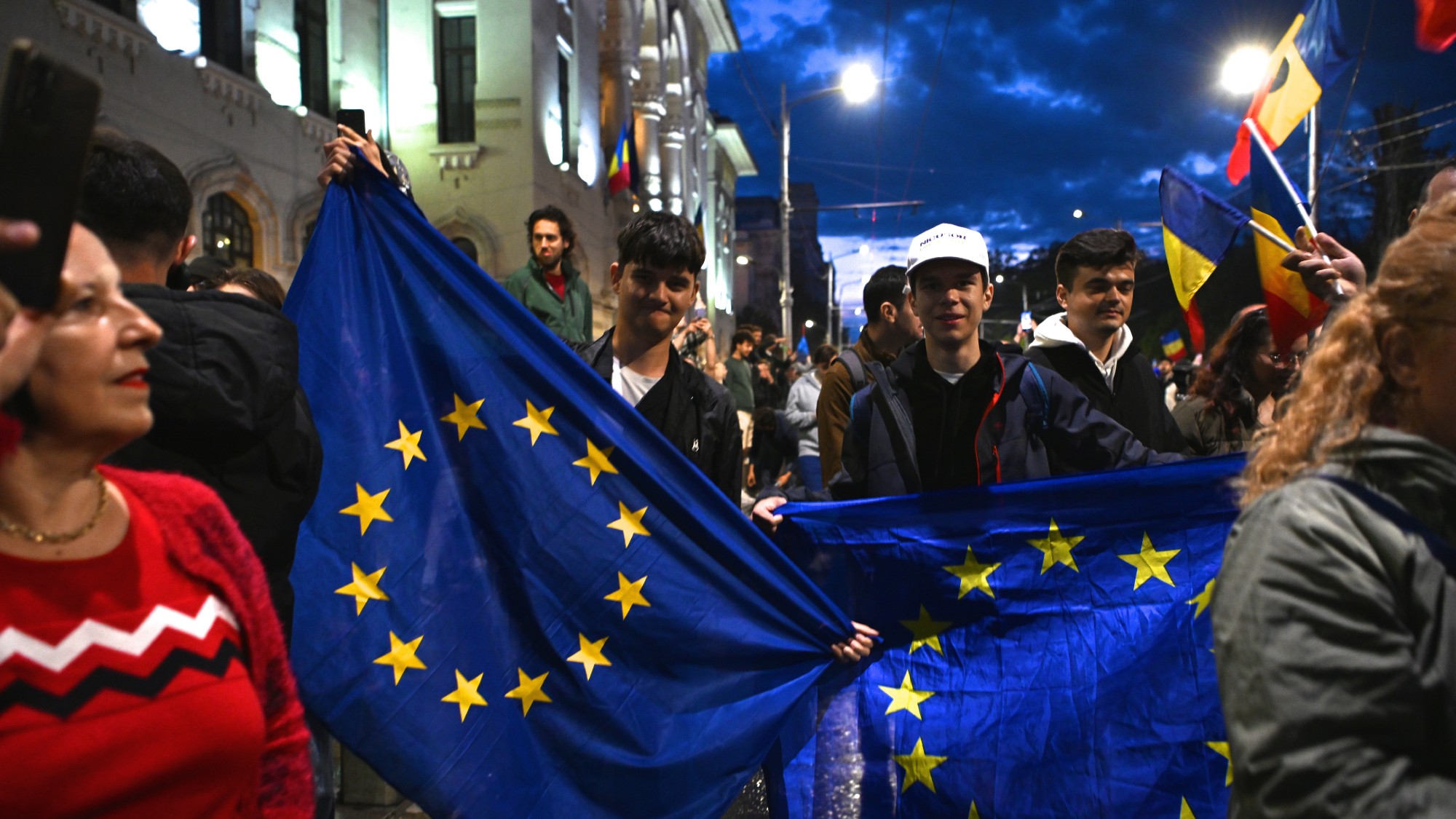 Two men holding EU flags among a crowd of demonstrators