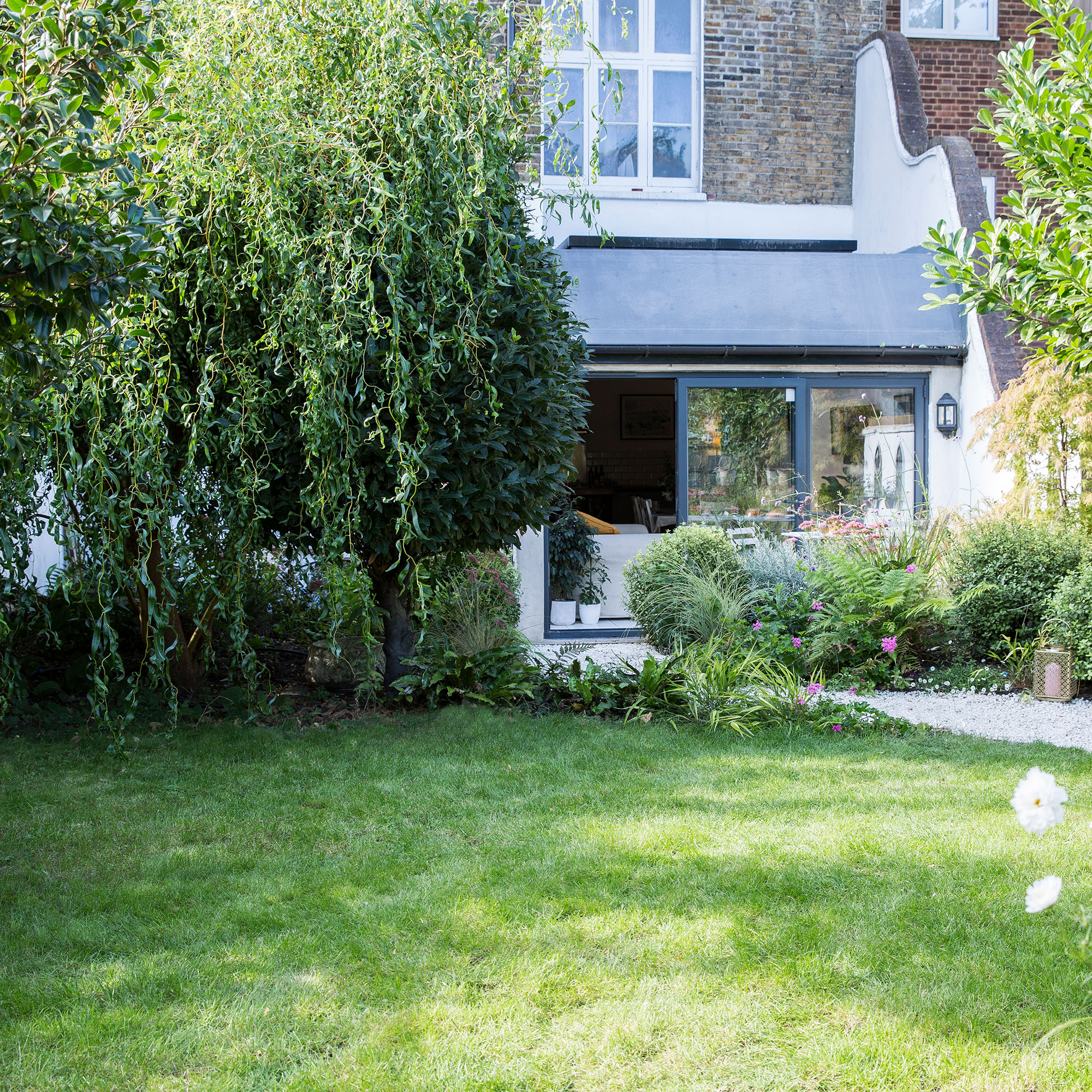 exterior of house with willow tree and lawn