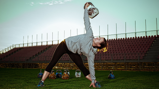Woman performing a kettlebell windmill outside