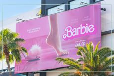 A billboard for the Barbie movie next to palm trees