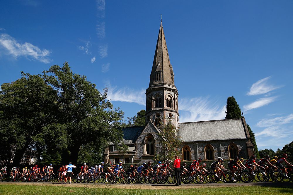 The field races past St Barnabas' Church on Ranmore Common during RideLondon
