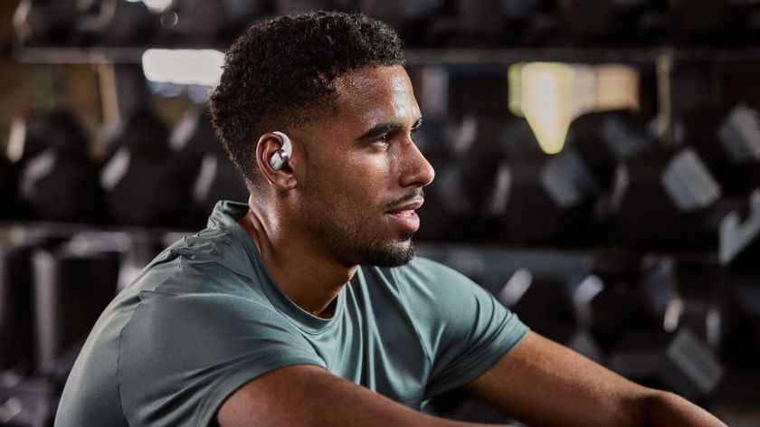 A man at the gym using headphones powered by Shokz OpenSound tech.