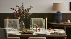 A formal dinner table set with autumnal decor