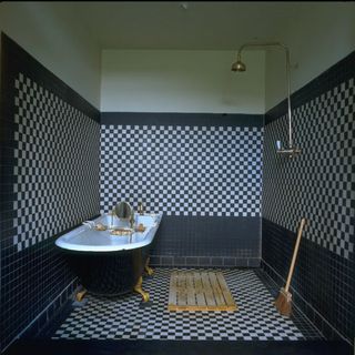 Black and white tiled bathroom with free-standing bath