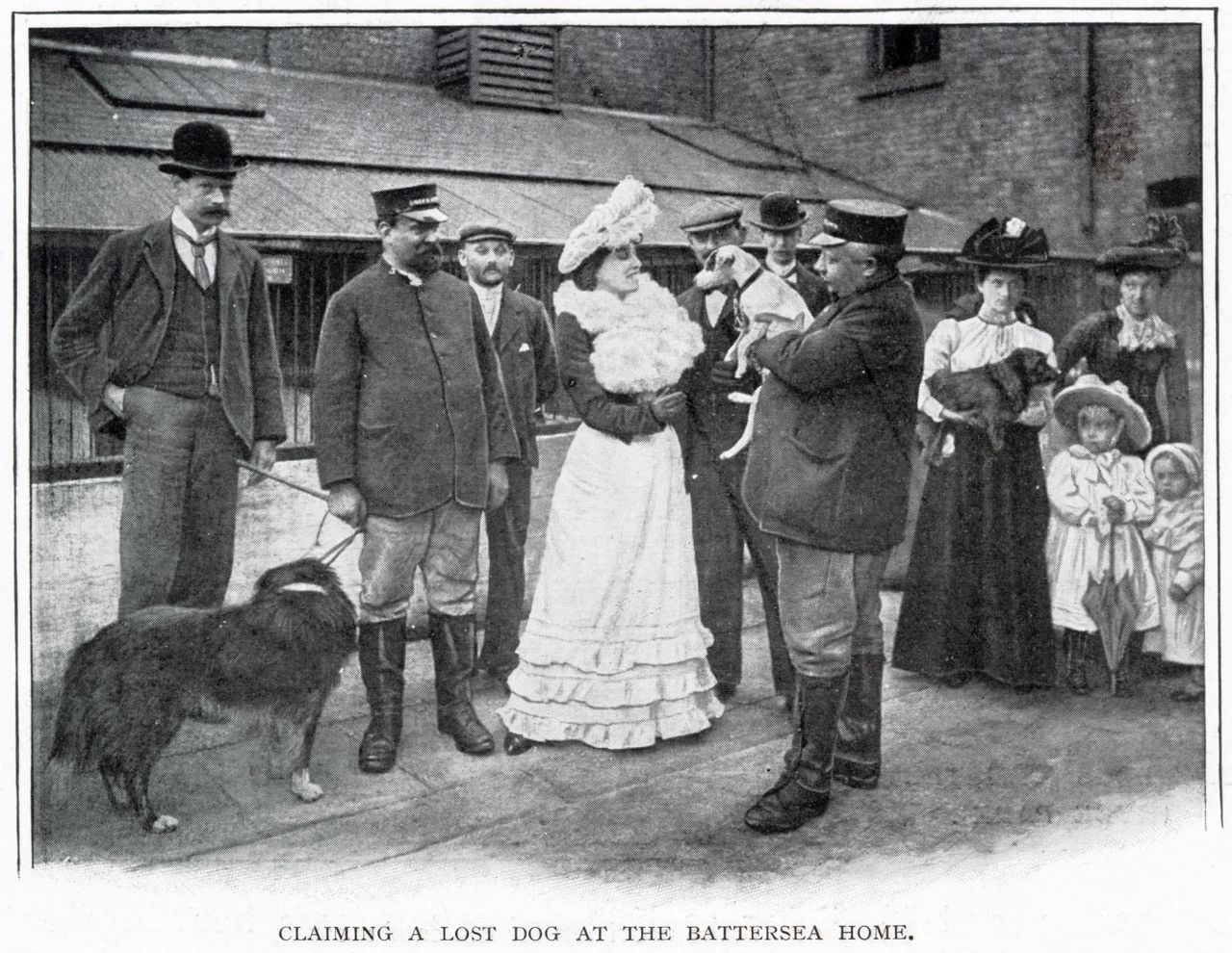Black-and-white photograph showing people outside Battersea Dogs Home claiming a lost dog. Men and women in Edwardian dress stand in a courtyard while a large dog waits on a lead.