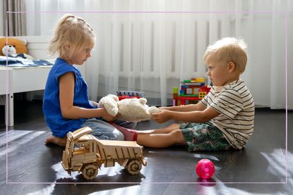 Two toddlers fighting over a toy