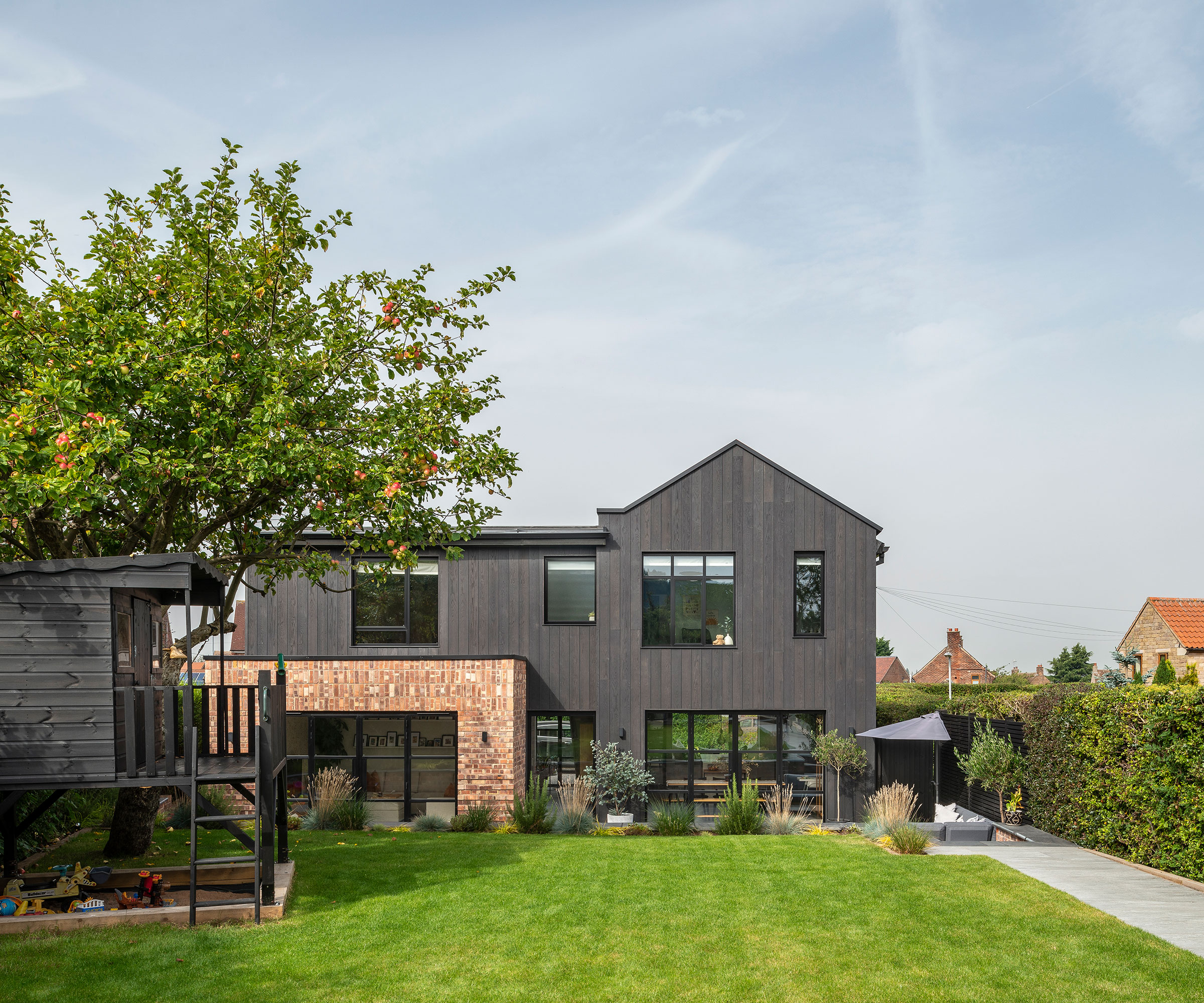 renovated and extended detached house that has been given an exterior makeover with black timber cladding