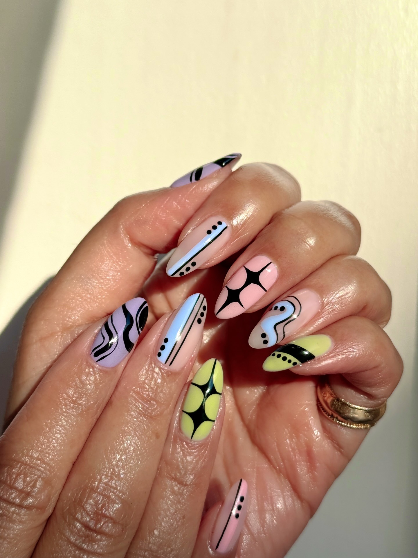 A close-up of fun pastel nail art with black detailing