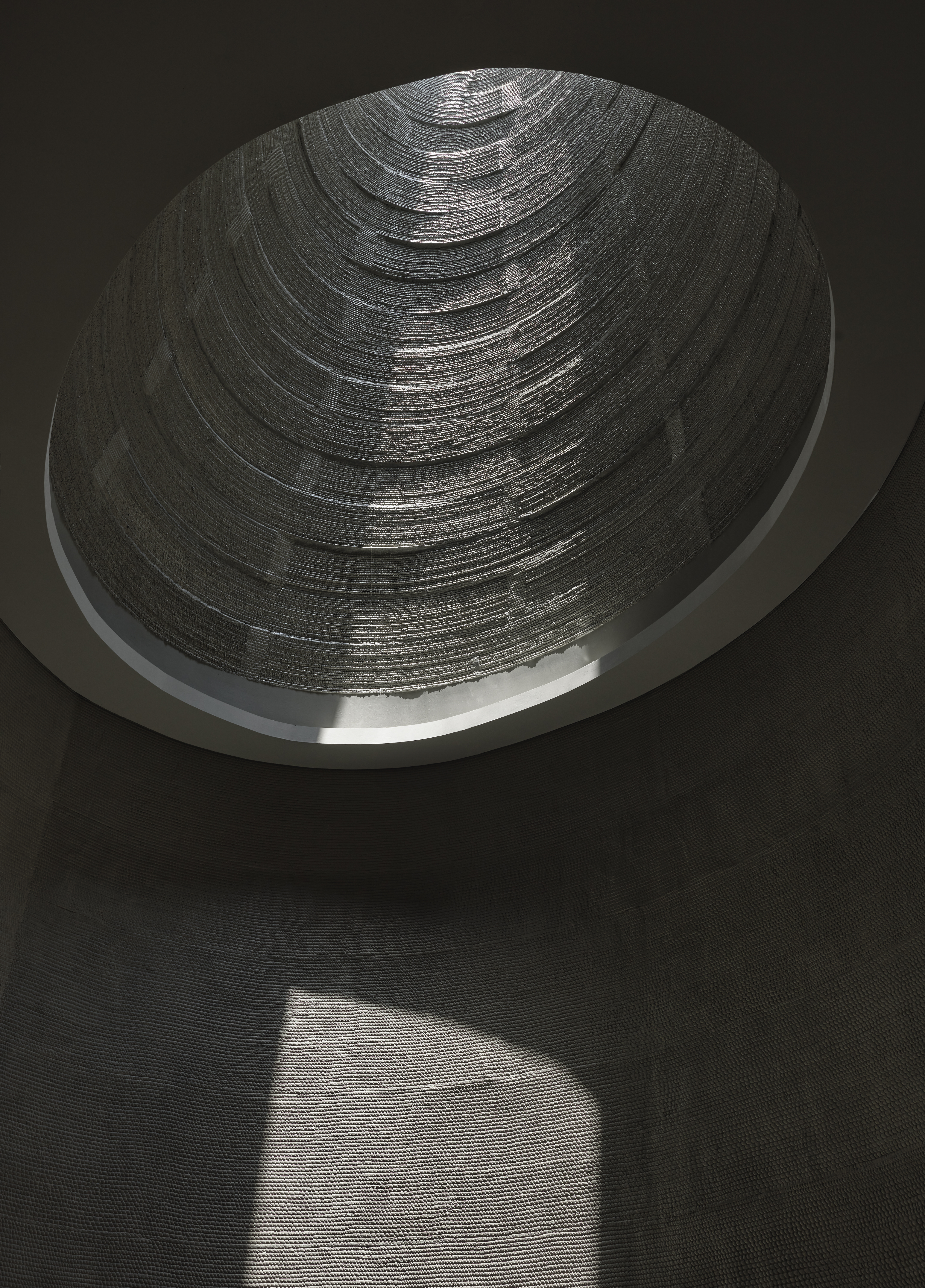 curved textured oculus with light coming down in singapore 3d-printed concrete house