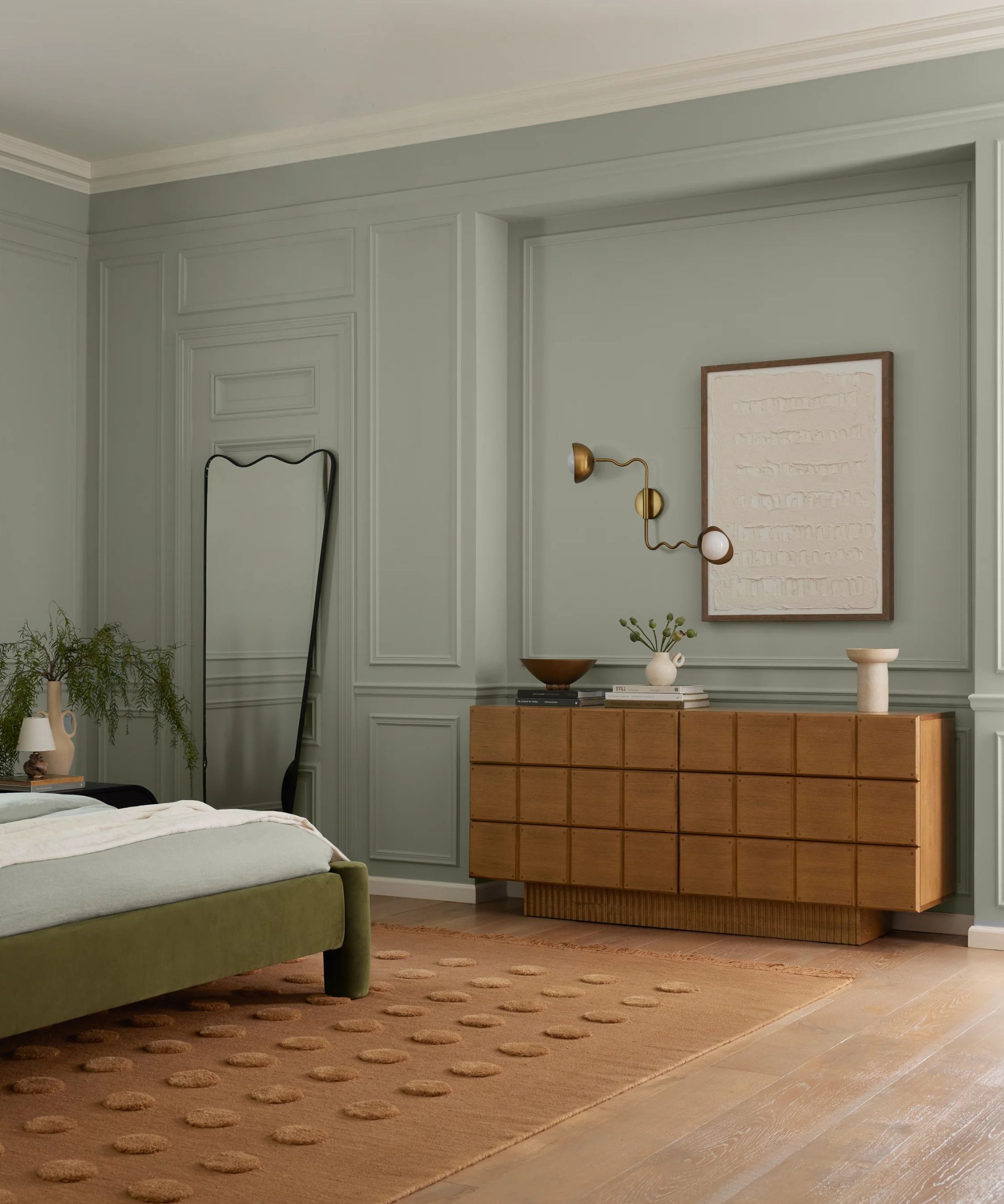 Pale blue bedroom with terracotta rug and wooden sideboard