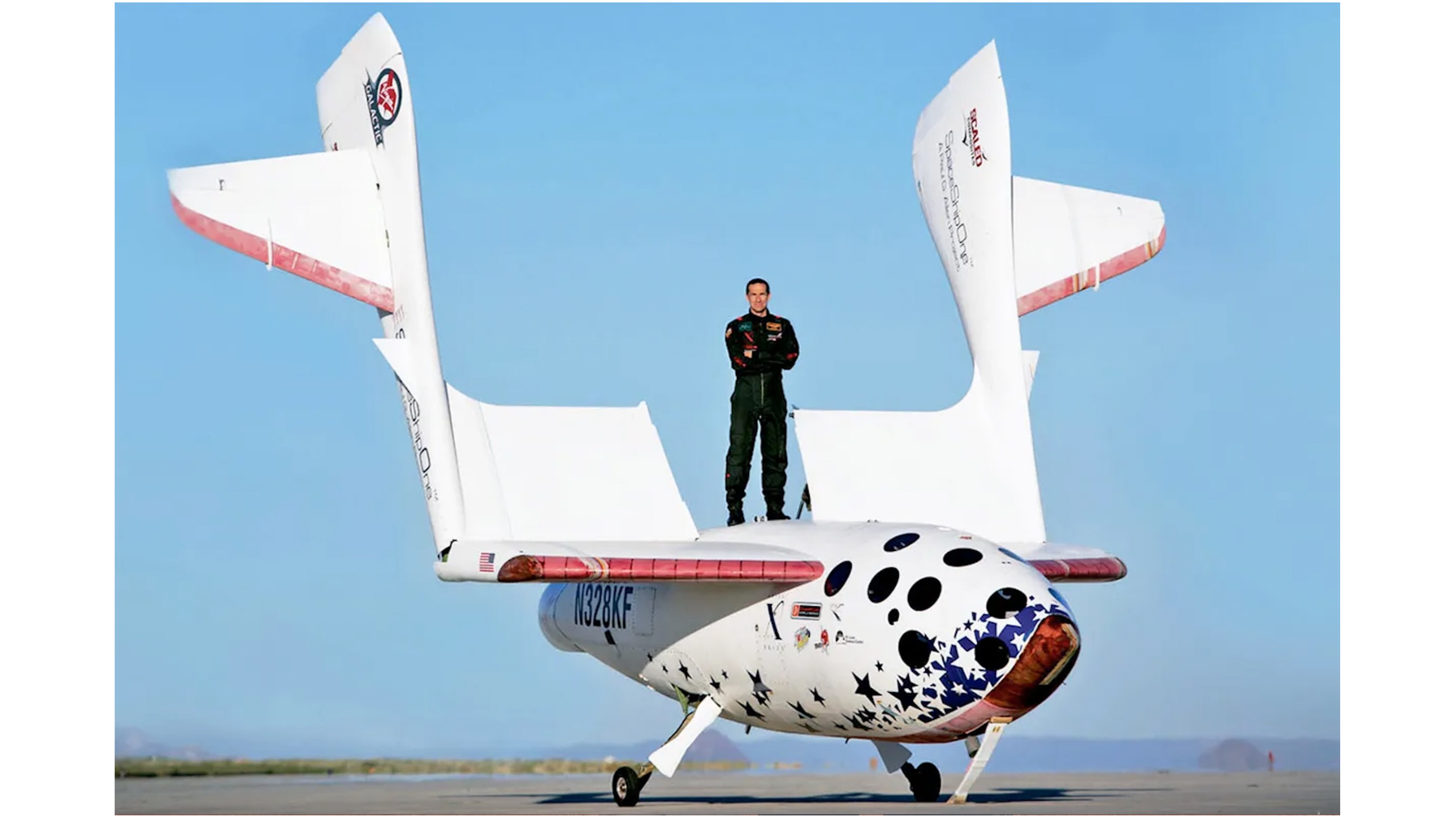 a man stands atop a white space plane on a runway
