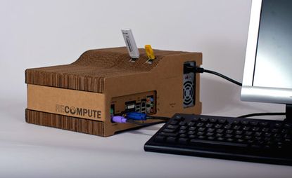 Cardboard box storing computer components hooked up to a monitor and keyboard