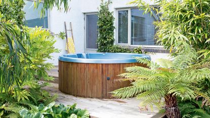 hot tub maintenance: hot tub on decking with surrounding plants