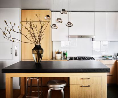 Black topped wooden kitchen island with kitchen behind