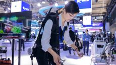 A woman demonstrates walking with an exoskeleton robot at the 2023 World Intelligent Manufacturing Conference in Nanjing, China 