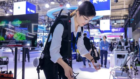 A woman demonstrates walking with an exoskeleton robot at the 2023 World Intelligent Manufacturing Conference in Nanjing, China 