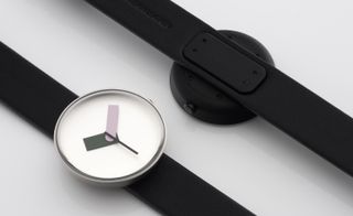 Two black watches, one face-down, the other face-up showing the minimalist design