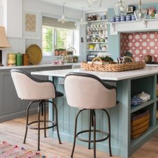 blue kitchen with pink bar stools at island