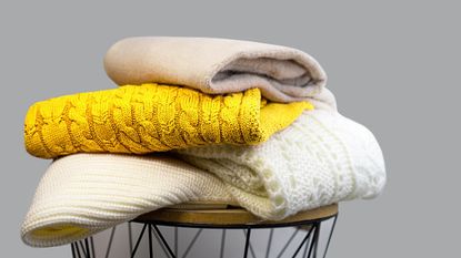 A pile of knit clothes on a stool