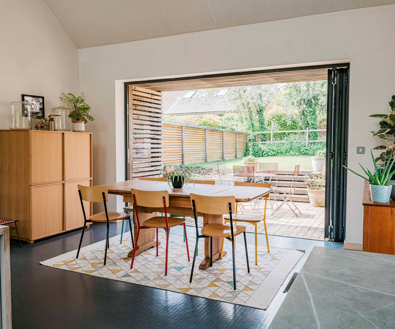 interior shot of eco house with dark rubber style flooring and large bi-fold doors with slatted section in reveal