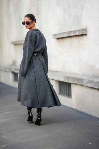 woman in gray oversized sweater, gray midi skirt, and black boots