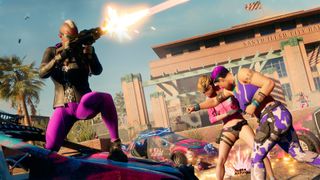 2022 games - A screenshot from Saints Row, with one Saint crouching on the hood of a car and firing an assault rifle as another delivers a haymaker to an enemy nearby.