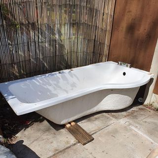 white bathtub with bamboo wall