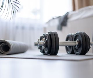 A home gym in a white room with black gym equiptment