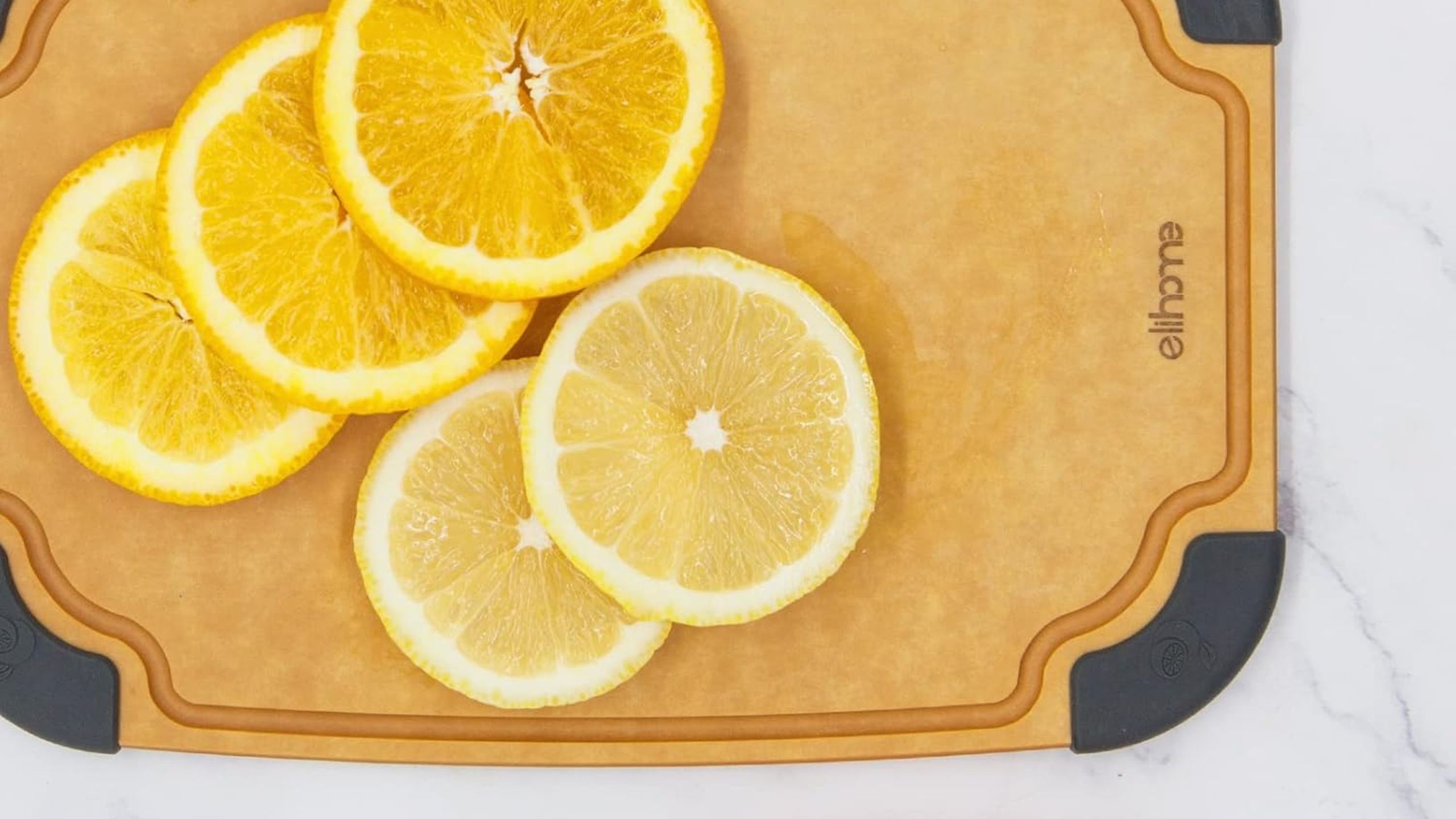 A light brown paper fiber cutting board with fresh lemon slices on top of it 