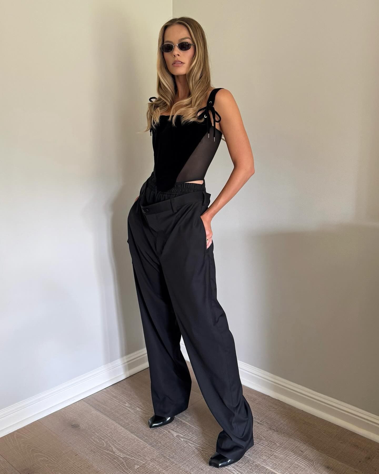 Margot Robbie wears a corset top and wide-leg trousers