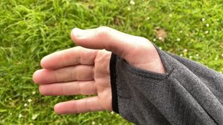 A close-up of a man's hand showing the thumb loop on his Columbia Park View Fleece.