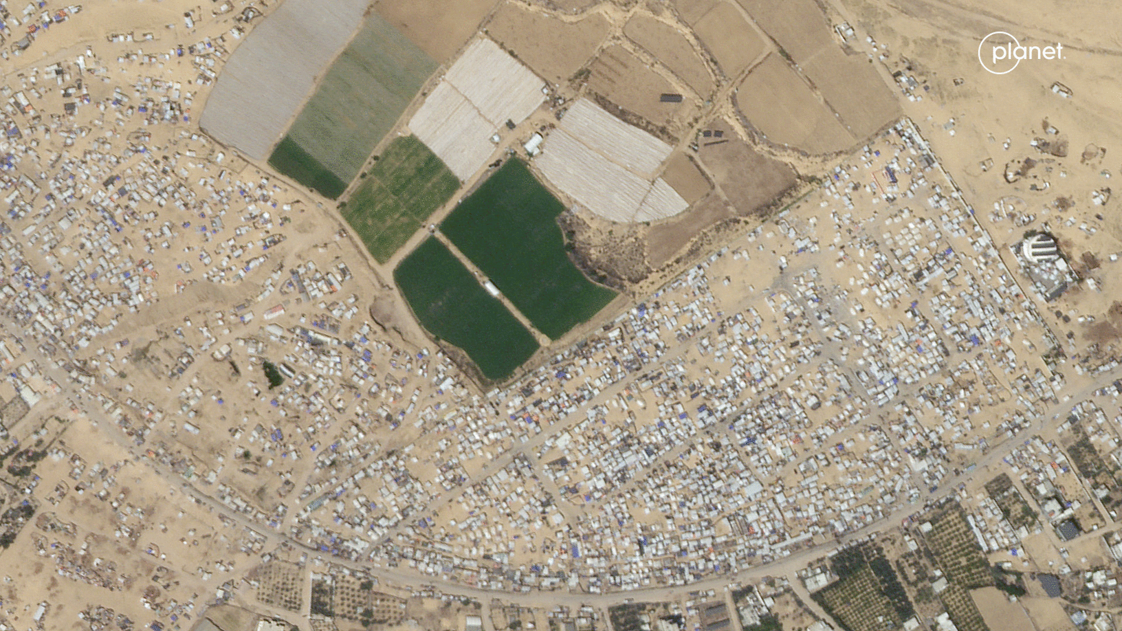 A desert landscape aerial shows before and after tents are assembled across a vast swath of land.