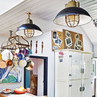 kitchen with nautical lighting fixtures and hanging saucepan storage rack