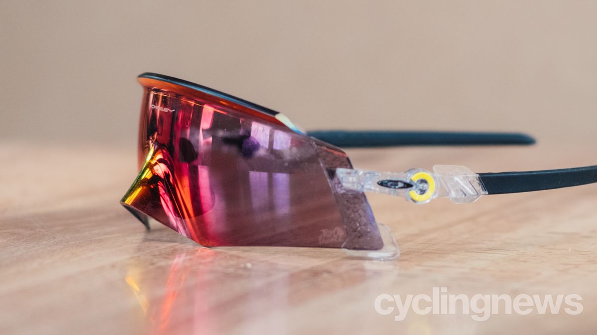 A red pair of sunglasses sits on a wooden tabletop