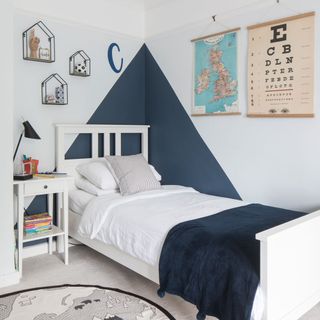 Children's bedroom with painted triangle motif and mountain themed rug