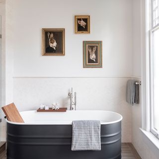 a white bathroom with a grey bathtub in a house which once belonged to Meg Ryan