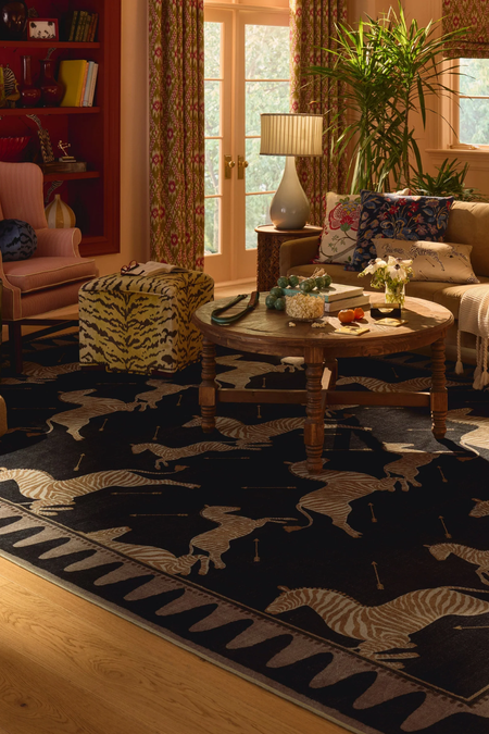 Eclectic, pattern-filled living room featuring a tiger print ottoman, wooden coffee table, and zebra motif area rug