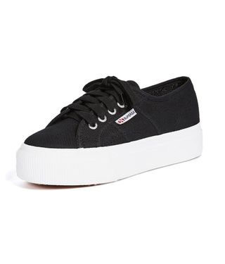 Die Canvas-Plateau-Sneaker von Superga sind schwarz und haben eine weiße Sohle