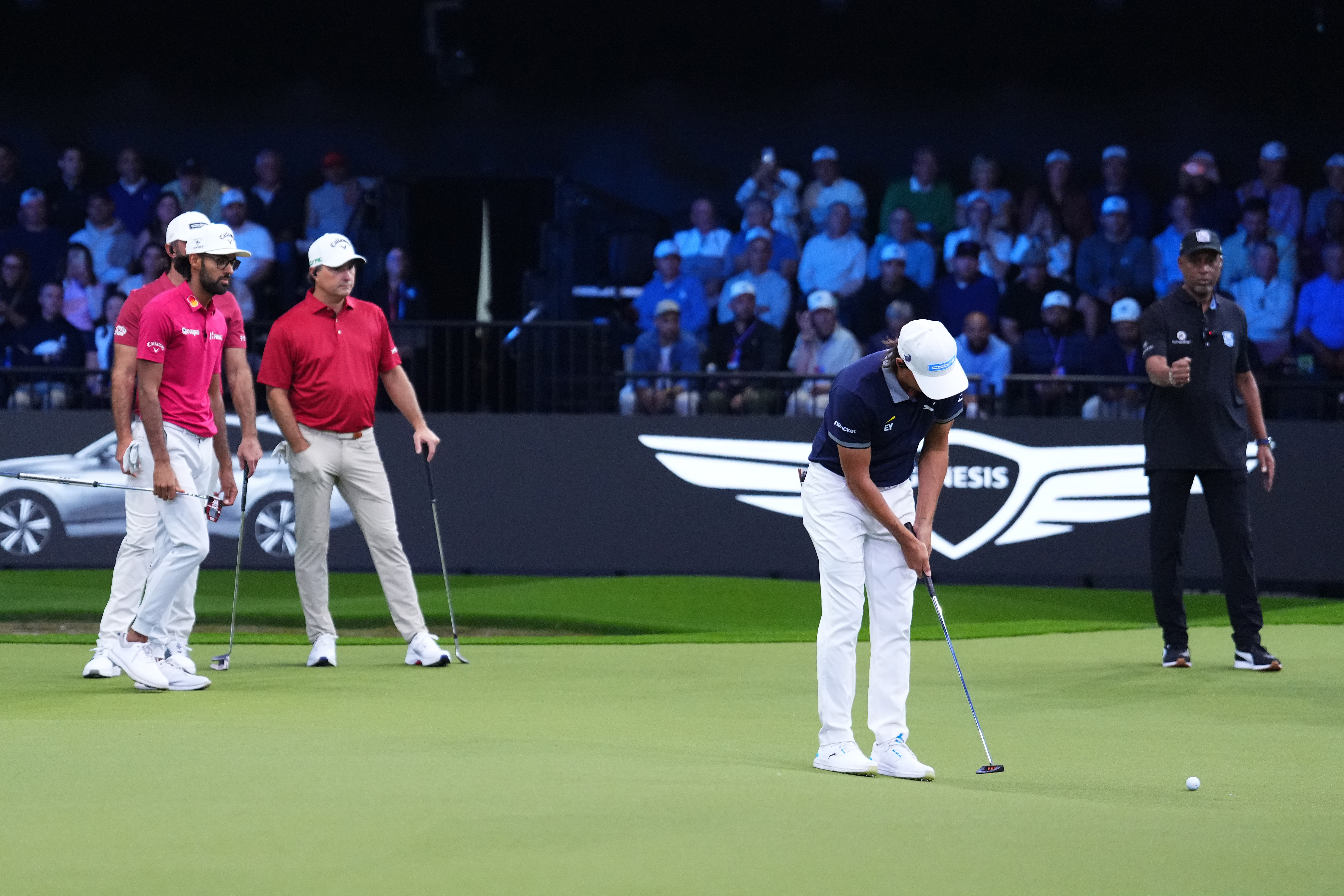 Rickie Fowler hits a putt with Jupiter Links GC stood behind him
