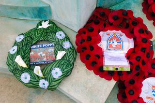 A white poppy wreath next to a red poppy wreath at a war memorial in Bromley, South London