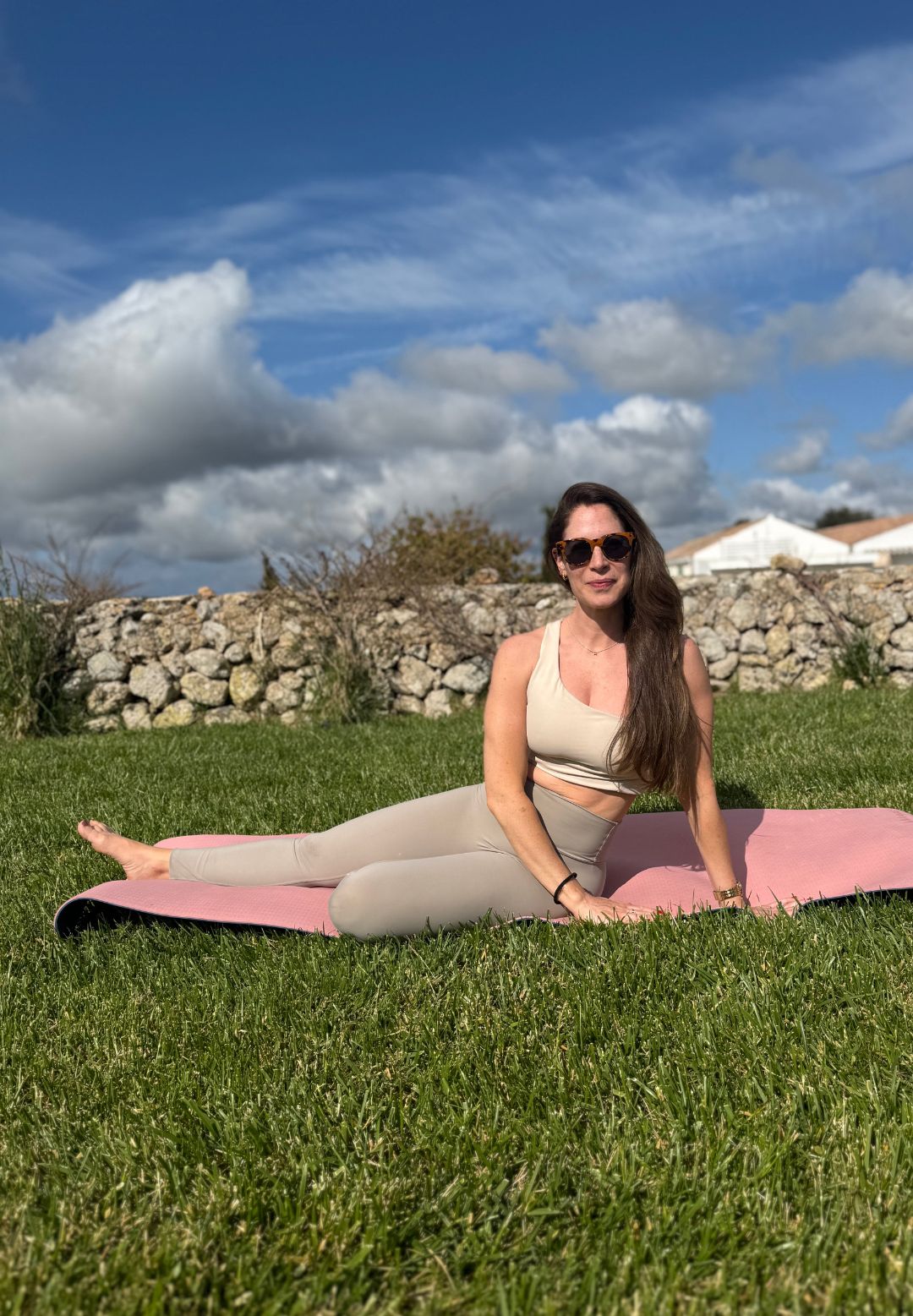 Health writer Anna trying the Pilates teaser move in a garden on a yoga mat