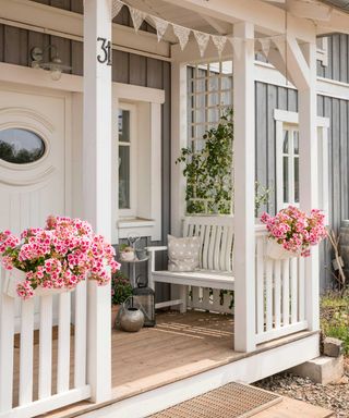 porch with bench and pink flowers in planter