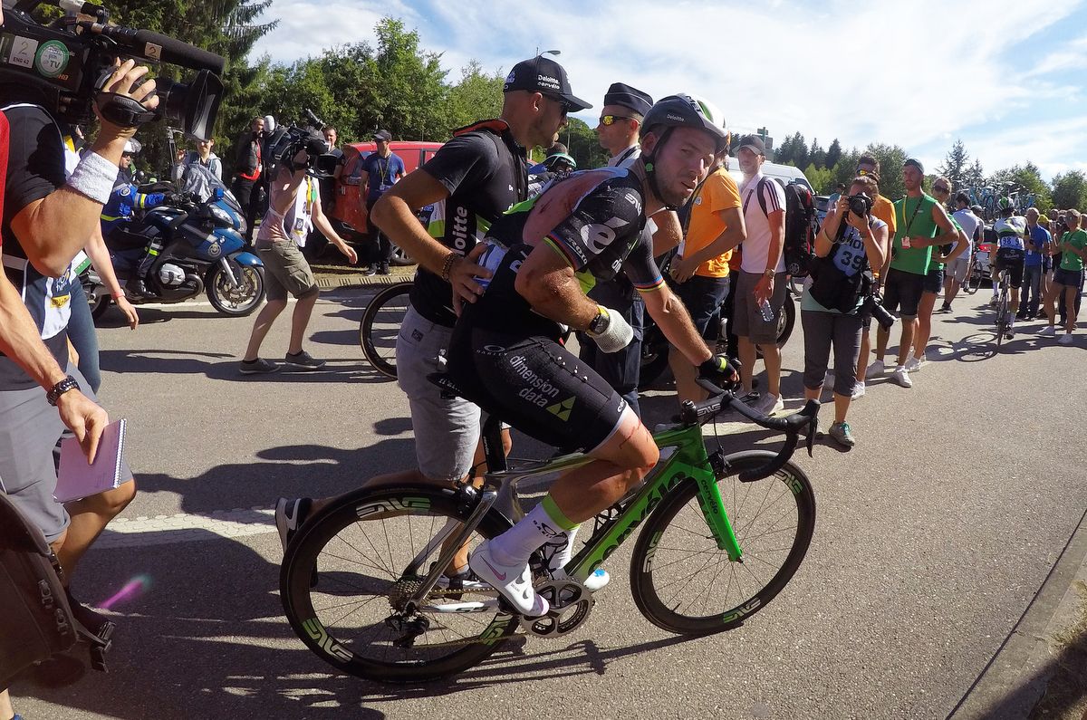 Mark Cavendish rides back to the team bus after the crash