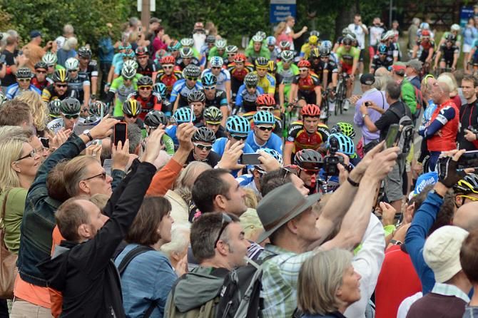 Fans take photos of the peloton