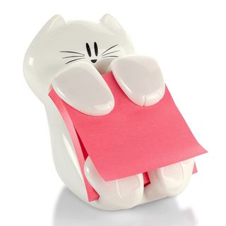 A white plastic cat holds some pink Post-It notes