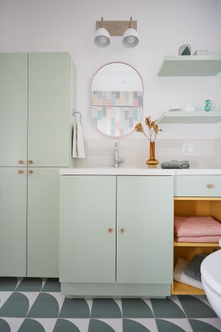 Bathroom with mint cabinets and white walls